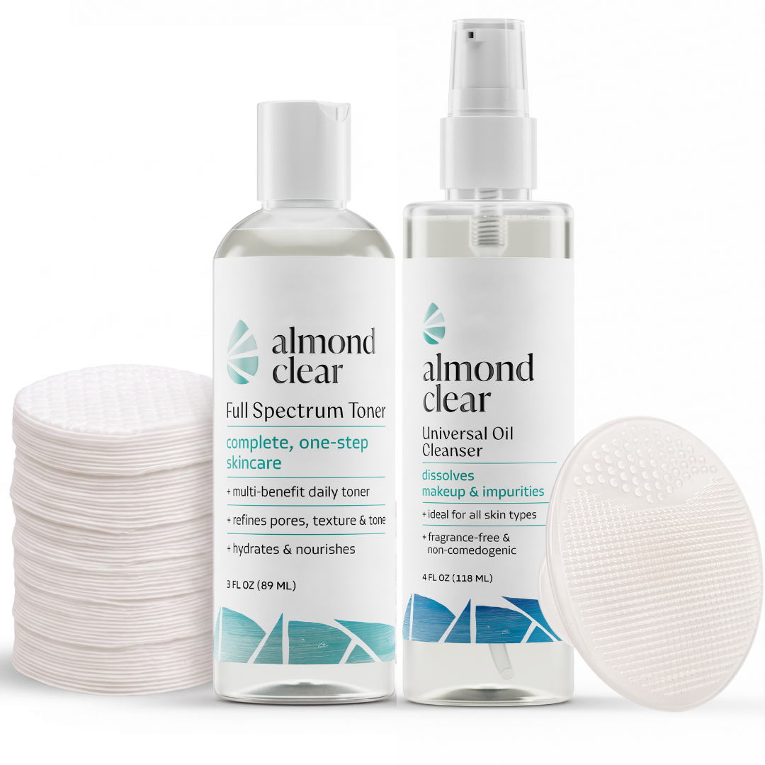 Almond Clear skincare set featuring a Full Spectrum Toner bottle, a Universal Oil Cleanser spray bottle, a stack of bamboo facial rounds on the left, and a silicone scrubber on the right, all on a white background.